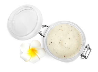 Jar of exfoliating salt scrub and plumeria flower on white background, top view