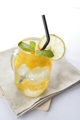 cold iced mango peach fruit juice with lemon mint leaf in glass jar white background asian beverage halal menu