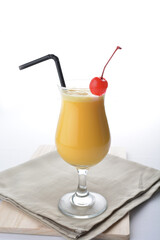 cold iced orange fruit juice with red cherry in cocktail glass white background asian beverage halal menu