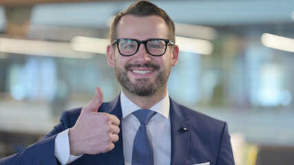 Middle Aged Businessman showing Thumbs Up Sign
