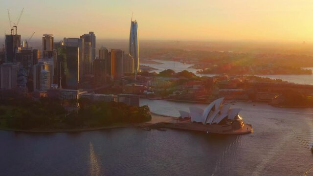 Sydney Opera House With High-rise Buildings And Skyscrapers In Background At Sunset In NSW, Australia. - aerial