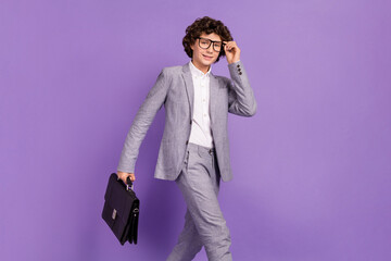 Photo of successful student pupil guy walk street carry case wear grey suit isolated violet color...