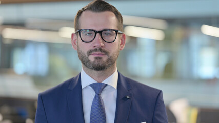 Portrait of Middle Aged Businessman Looking at Camera