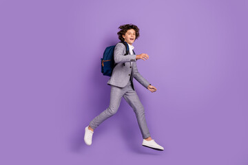 Photo of nice funky active pupil guy jump run move wear backpack grey suit footwear isolated violet color background