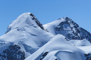 The peaks of Monte Rosa covered by glaciers near the village of Zermatt, Switzerland - June 2021