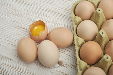 Close-up view of raw chicken eggs in egg box on wooden background. Raw chicken eggs in egg box organic food for good health high protein .