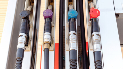 Multi-colored taps for supplying fuel at a gas station. Fuel dispensing cranes close-up. Fuel cost...