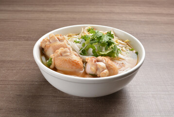 cook hot clear soup bowl with chicken drum stick and vermicelli noodle mee and vegetables in wood background healthy asian halal menu