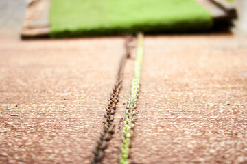 Astroturf and wooden plank jetty attached by a green rusted chain with multiple speedboats moored...