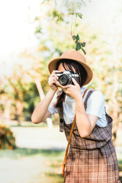 Portrait of a beautiful teenager girl making photo with camera in garden, 