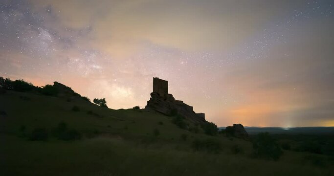Milky way timelapse during a cloudy night in Zafra Castle, Guadalajara, Spain. famous game of thrones location.