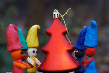 Figures of colorful gnomes with a toy Christmas tree.