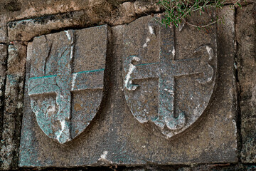 Medieval heraldica on castle stone walls, stone caving, cultural heritage, armorial details