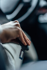 Picture of a hand, pulling the seat belt.