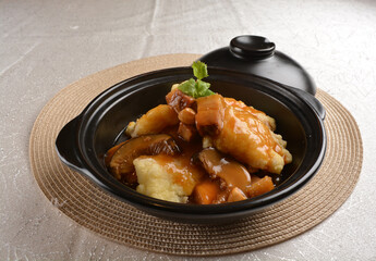 deep fried grouper fish fillet seafood in black hot clay pot with vegetables and mushroom in dark soy sauce white background premium asian halal menu