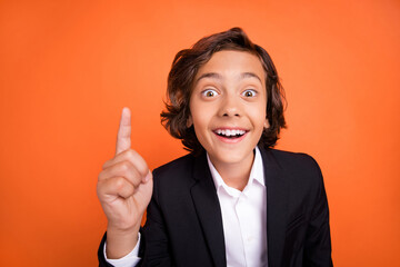 Photo of young happy smart shocked astonished small boy point finger up idea isolated on orange color background