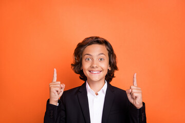 Photo of young happy amazed cheerful boy point finger up information isolated on orange color background