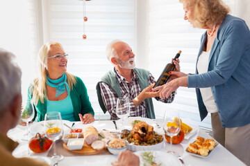 Fototapeta na wymiar Two senior couples drinking wine for Thanksgiving dinner