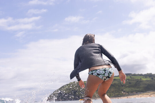 Caucasian surfer woman seen from behind on a wave