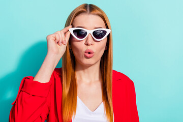 Photo of impressed funky orange hair lady wear red blazer arm dark glasses lips pouted isolated cyan color background