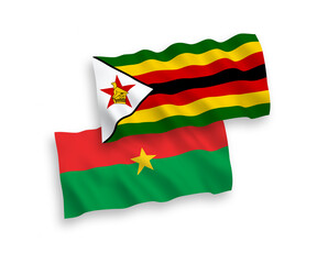National vector fabric wave flags of Burkina Faso and Zimbabwe isolated on white background. 1 to 2 proportion.