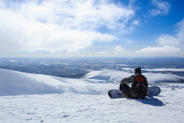 ready to descent snowboarder on the mountain and arctic winter lanscape behind him in polar russian ski resort