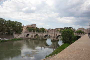 Obraz premium Photoscape of St. Angelo Bridge on cloudy day in summer 2021 Italy.Pedestrian bridge, built in 134 A.D., with travertine marble fascias and spanning the River Tiber.