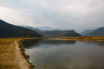 footpath along the river through the fields with harvest in the mountain region