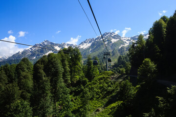 ropeway cabins in caucasus mountains covered with forest and snow