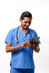 Young indian doctor using smartphone over white background.