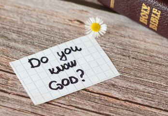 Do you know God and Jesus Christ? Closeup of a handwritten note on wooden background with holy...