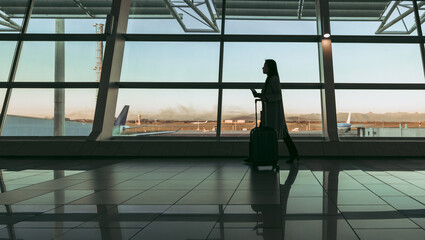 Fototapeta premium Silhouette of a traveler walking at airport