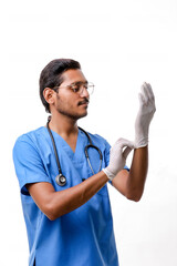 Young indian Doctor putting on protective gloves isolated on whi