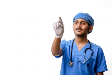 Young indian male doctor pointing with finger over white backgro