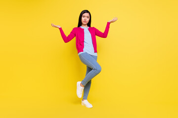 Fototapeta na wymiar Full body photo of sad brunette millennial lady hold empty space wear pink sweater jeans isolated on yellow background