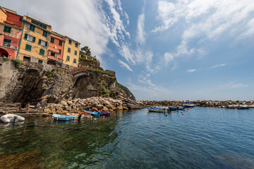 Fototapeta na wymiar The famous Riomaggiore village with small boats moored in the port, Cinque Terre National Park in Liguria, La Spezia, Italy, Europe. UNESCO world heritage site.