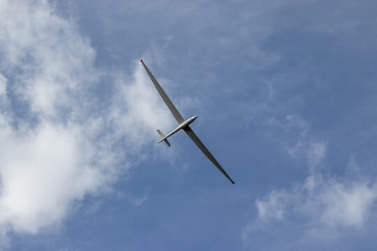 Glider against blue cloudy sky. Single seat high performance sailplane.
