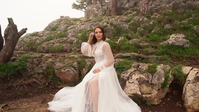 photo shoot of a model in a wedding dress in the mountains in cold foggy weather