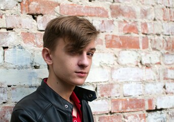 Portrait of a seventeen year old guy on blurred background. Expressive look. Youthful facial skin...