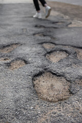 Broken pavement, potholes in the asphalt, large and deep holes or potholes, poor work of road services or improper technology of laying asphalt in cities. large potholes are unsightly and dangerous