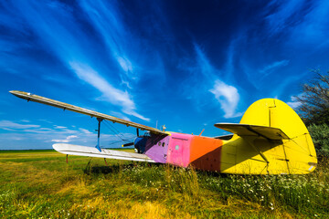 Abandoned old Antonov An-2 airplane grounded on airport field under blue sky