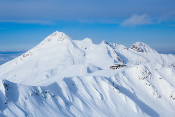 peak and cafe on the top of the ridge in snowy caucasus mountains in ski resort