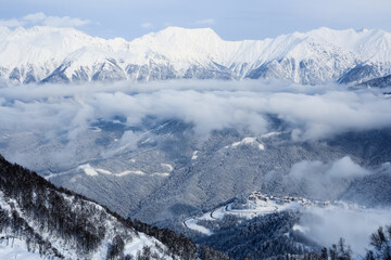 road to ski resort hotels and high mountains covered with snow and clouds in Sochi