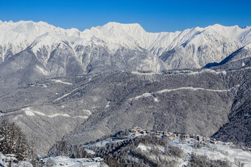 snowy mountain ridge and gorup of the hotels in Rosa Khutor ski resrot Sochi