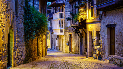 Narrow stone old town alley with cobbled streets. Santillana del Mar.