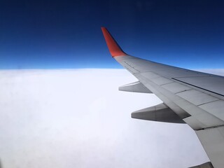 Airplane wing in the blue sky