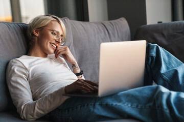 Smiling mid aged blonde woman studying online