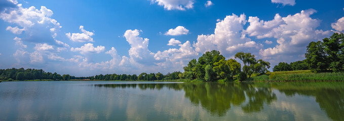 Fototapeta premium Low angle shot of the beautiful sky captured from a lake in a field