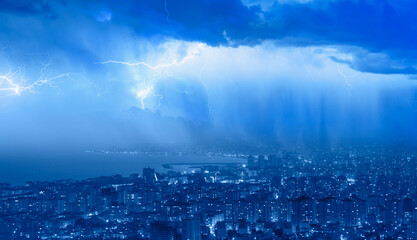 Lightning thunderstorm flash over the city at blue night sky - Lightning storm over city in blue...