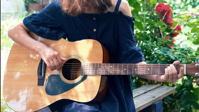 girl playing guitar in the garden